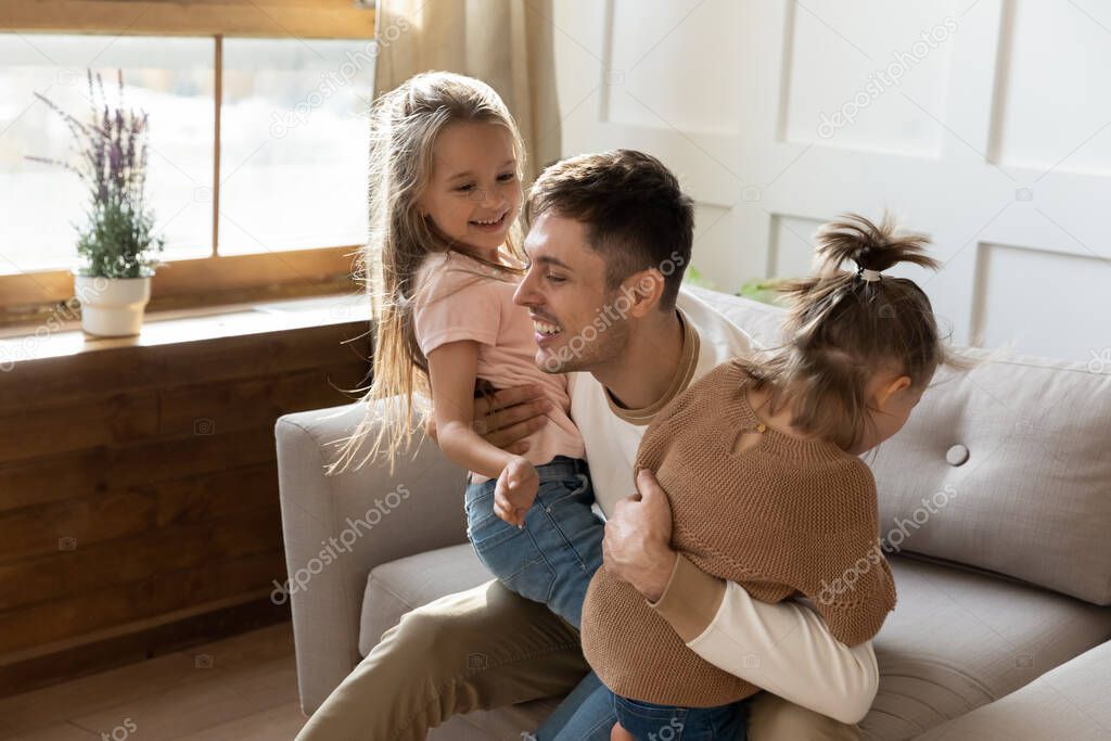 Daddy play with two daughters at home feels happy