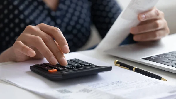 Close up woman calculating finances, using calculator and laptop — Stock Photo, Image