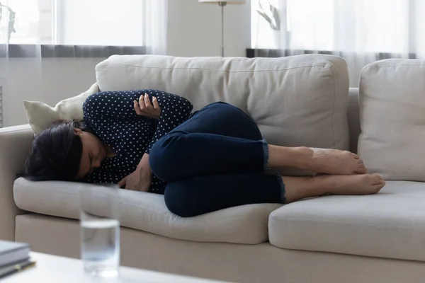 Unhappy frustrated Asian young woman lying on couch alone — Stock Photo, Image