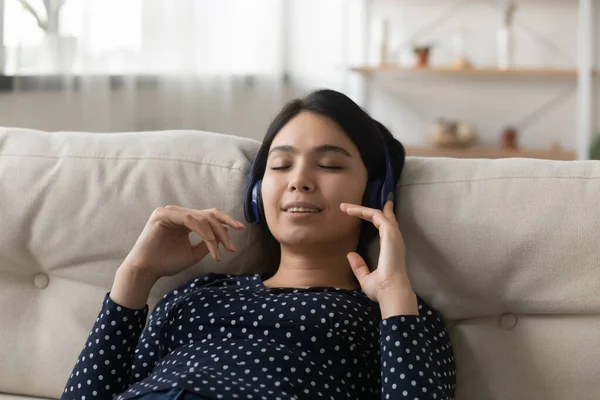 Gros plan paisible asiatique jeune femme portant des écouteurs profiter de la musique — Photo