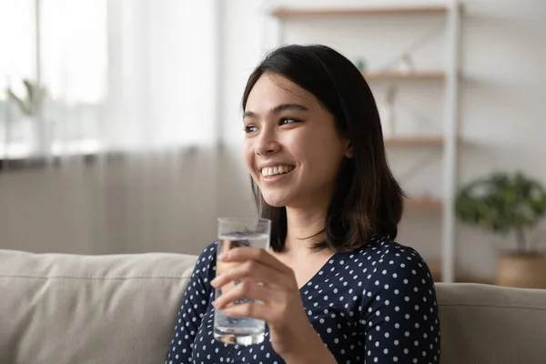 Gros plan rêveur souriant asiatique femme tenant verre d'eau — Photo