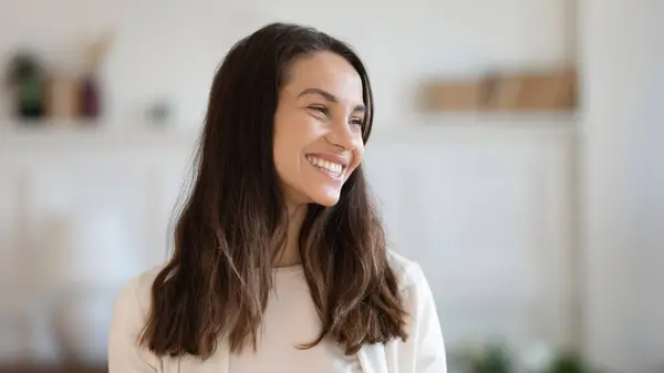 Überglückliche Millennial-Frau steht lachend im Haus und blickt glücklich zur Seite — Stockfoto