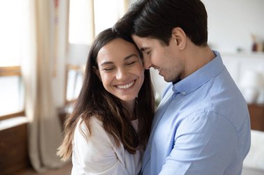 Bakıcı eşler oturma odasında kucaklaşıp birlikte güzel anların tadını çıkarıyorlar.
