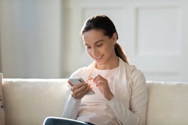 Sosyal ağda cep telefonu sohbeti yapan mutlu genç bir kadın.
