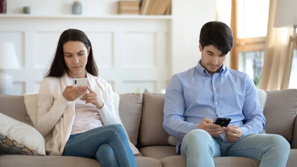 Зачарованные молодые мужчины и женщины, проводящие время в Интернете с помощью смартфонов — стоковое фото