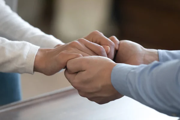 Giovane coppia amorevole che si tiene per mano sostenendo confortante in un momento difficile — Foto Stock