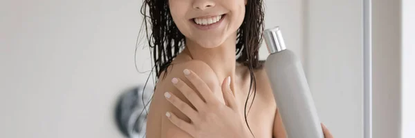 Positive lady with shiny smile showering in bathroom advertizing shampoo — Stock Photo, Image