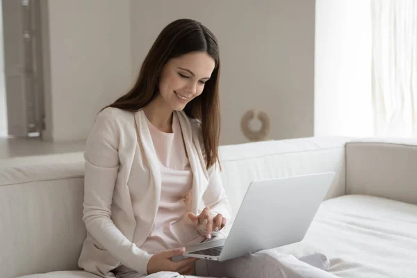 Sonriente mujer joven se concentró en el trabajo en línea utilizando el ordenador portátil — Foto de Stock