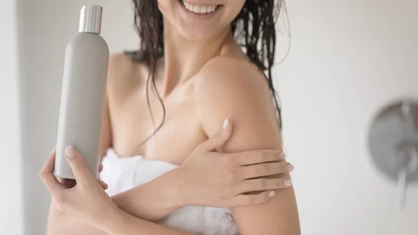 Young female touching skin checking its condition after using lotion — Stock Photo, Image