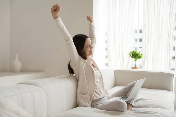 Mujer contenta freelancer estirando brazos en deleite distraído de la pantalla — Foto de Stock