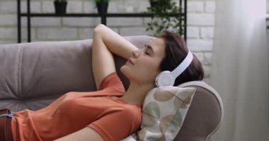 Rahat genç Avrupalı kız kulaklıkla sakin müzik dinliyor..