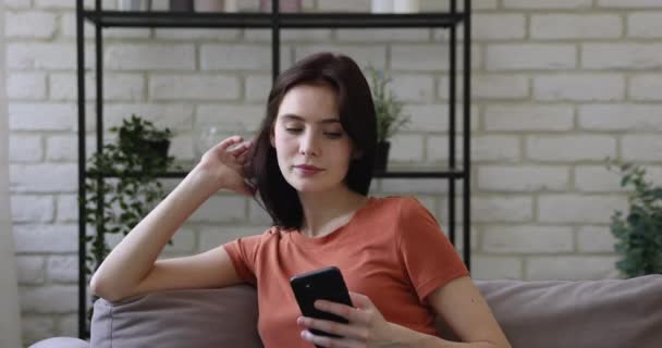 Smilende ung kvinde ser sjove video på smartphone. – Stock-video