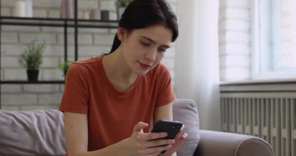 Mooi millennial meisje lachen om grappige video-inhoud op de smartphone. — Stockvideo