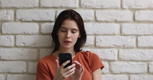 Ung smuk kaukasisk pige ved hjælp af smartphone applikationer. – Stock-video