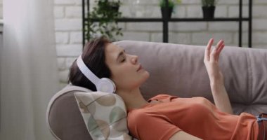 Huzurlu, dingin, milenyum kadını kulaklıkla müzik dinliyor..