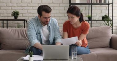 Odaklanmış genç evli çift banka ipoteği kredi anlaşmasını tartışıyor.