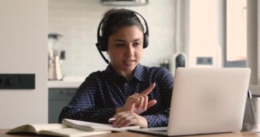 Odaklanmış genç Hintli etnik kökenli kız öğrenci çevrimiçi çalışıyor..