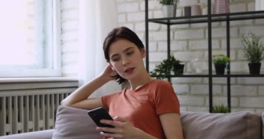 Çok neşeli genç bir kadın başarıyı kutluyor, telefonda mesaj okuyor..