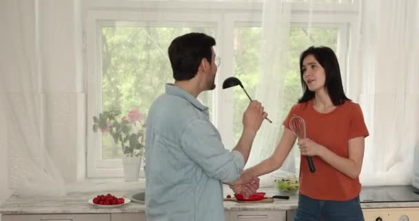 Feliz positivo millennial familia pareja cantando canciones en cocina. — Vídeo de stock