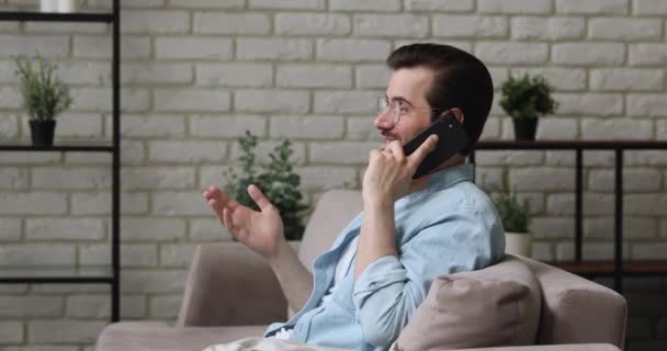 Ευτυχισμένος νεαρός άνδρας που κρατά συνομιλία κινητής τηλεφωνίας. — Αρχείο Βίντεο
