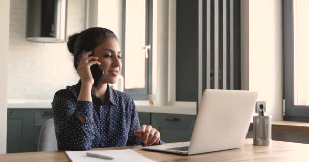 Heureuse femme d'affaires indienne ethnique consultant le client à distance par téléphone intelligent. — Video