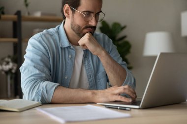 Odaklanmış bir adam olarak dizüstü bilgisayar ekranına bak.