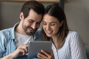 Mutlu çift internetten tablet alışverişi yapıyor.