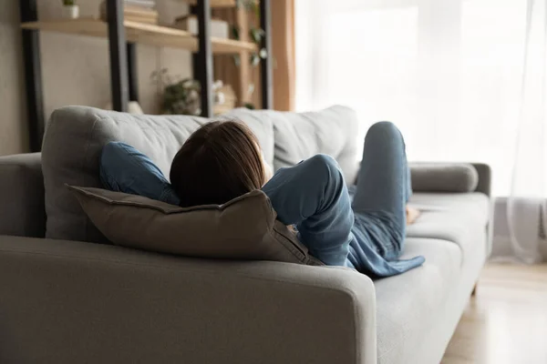 Tired woman relaxing on sofa in cozy living room — Stock Photo, Image