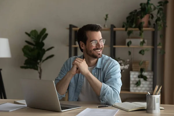 Smiling young man dream distracted from computer work — Stock Photo, Image