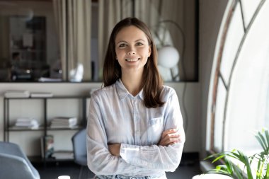 Ofiste kameraya bakarak motive olmuş genç bir bayan.