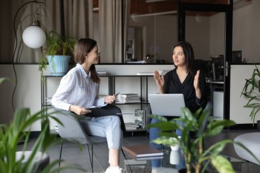 Genç Hintli kadın akıl hocası stajyerlerin iş prensiplerini anlatıyor.