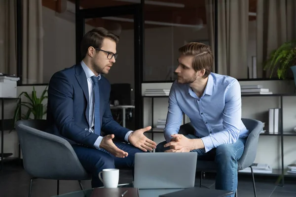 Qualified manager and client discussing loan agreement by laptop screen