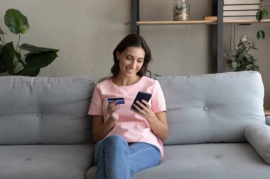 Gülümseyen Arap genç Hintli kadın internetten kredi kartı kullanıyor..