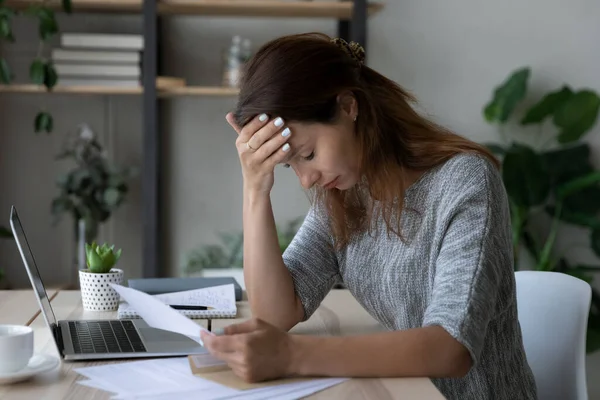 Depressieve jonge vrouw gestrest door het krijgen van bankschuld kennisgeving. — Stockfoto