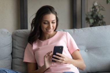 Mutlu genç melez kadın akıllı telefondan hoş bir mesaj okuyor..