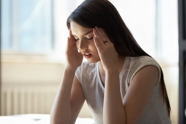 Close up stressed young woman touching temples, suffering from headache — Stock Photo, Image