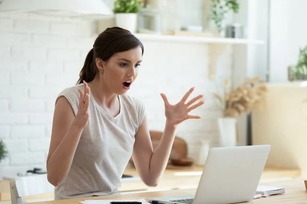 怒气冲冲的年轻女人看着手提电脑屏幕，看新闻 — 图库照片