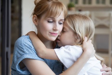 Sevgili anne ve küçük kızının evde kucaklaşması.