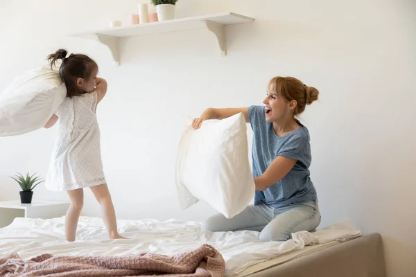 Madre felicissima e adorabile figlioletta che gioca a pillow fight — Foto Stock