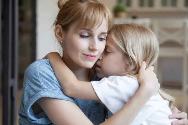 Gros plan mère aimante et petite fille étreignant à la maison — Photo