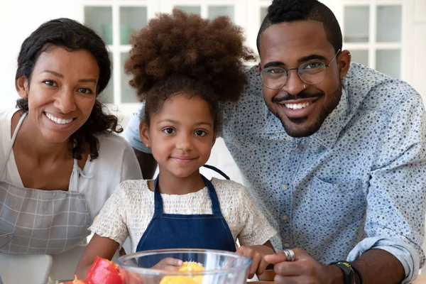 Portrait of happy black family of three at modern kitchen