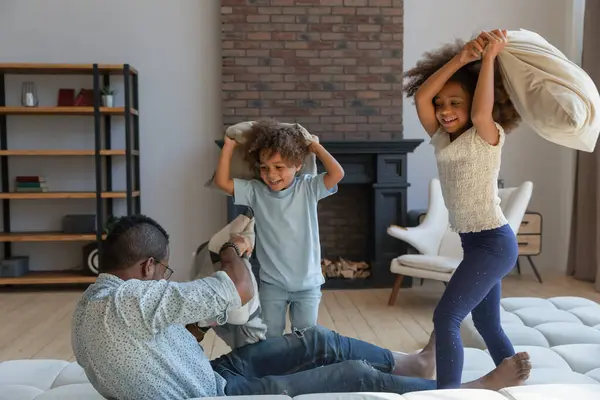 Lachender schwarzer Papa bei aktivem Spiel mit Kindern — Stockfoto