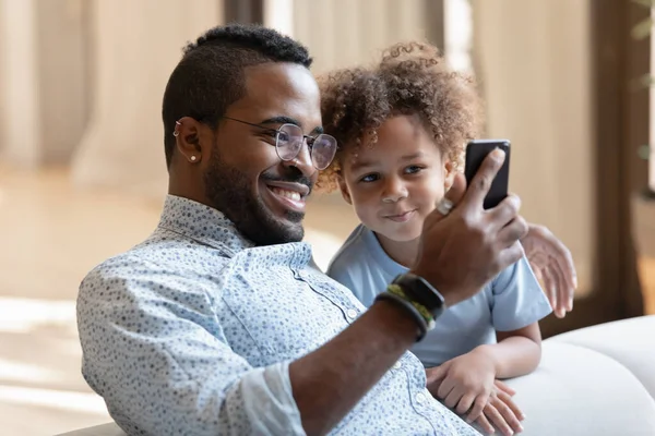 Sourire père africain montrant fils enfant drôle vidéo sur téléphone portable — Photo
