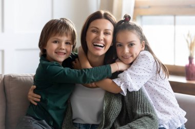 Minnettar iki çocuğun portresi gülümseyen anneye sarılıyor.