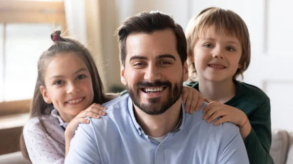 Portrét usmívajícího se mladého otce pózujícího se dvěma dětmi — Stock fotografie
