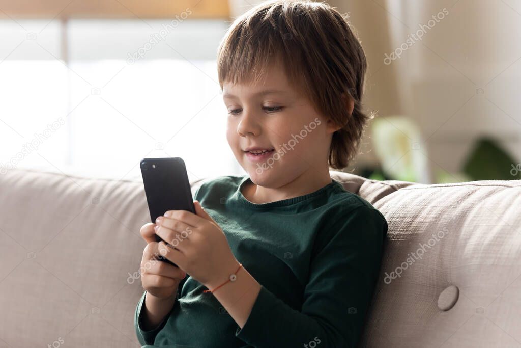 Small boy use smartphone playing game online