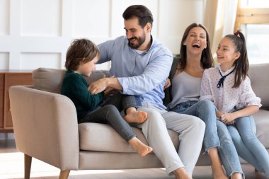 İki çocuklu neşeli ebeveynler evde oynuyorlar.