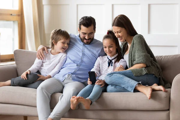 Famille heureuse avec enfants se détendre à la maison en utilisant un téléphone portable — Photo