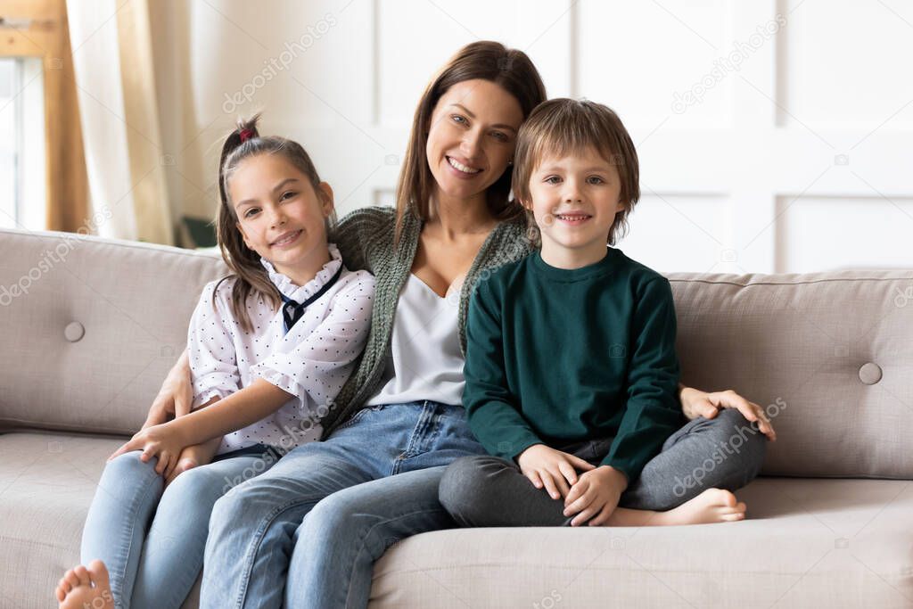 Portrait of happy mom with kids relax on sofa