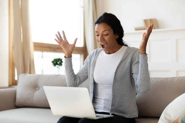 Mujer biracial aturdido conmocionado por noticias inesperadas en el ordenador portátil — Foto de Stock